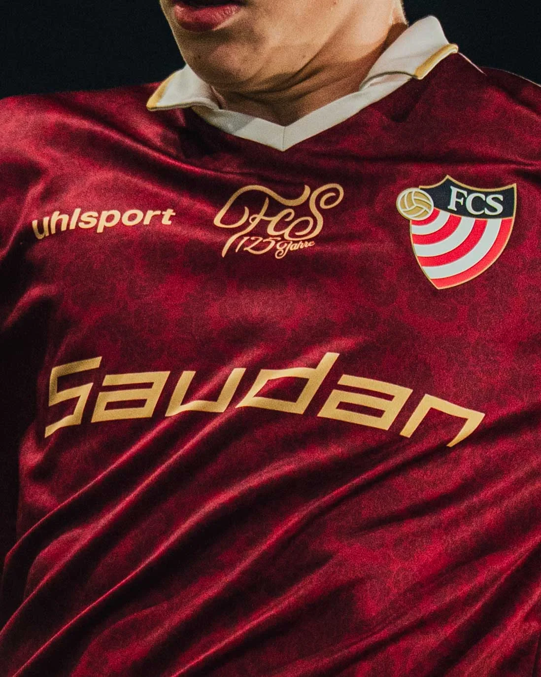 Nahaufnahme vom roten Trikot mit Vereinswappen