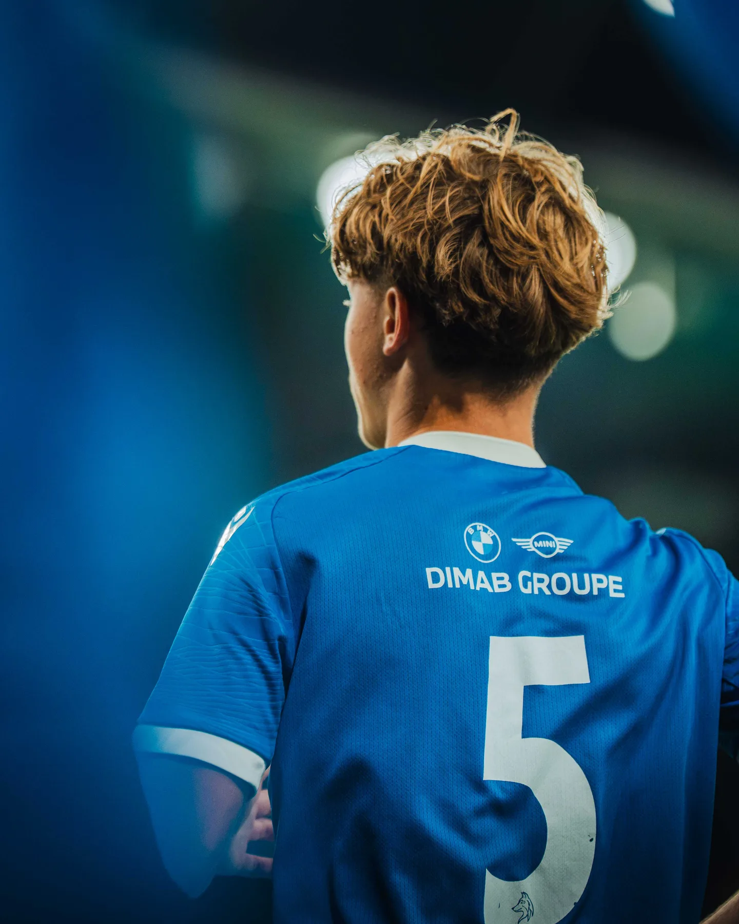 Spieler mit der Nummer 5 im blauen Trikot von hinten