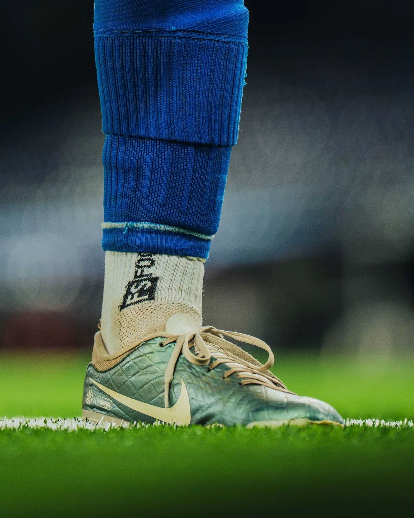 Blaue Stutzen und Fussballschuh auf dem Rasen