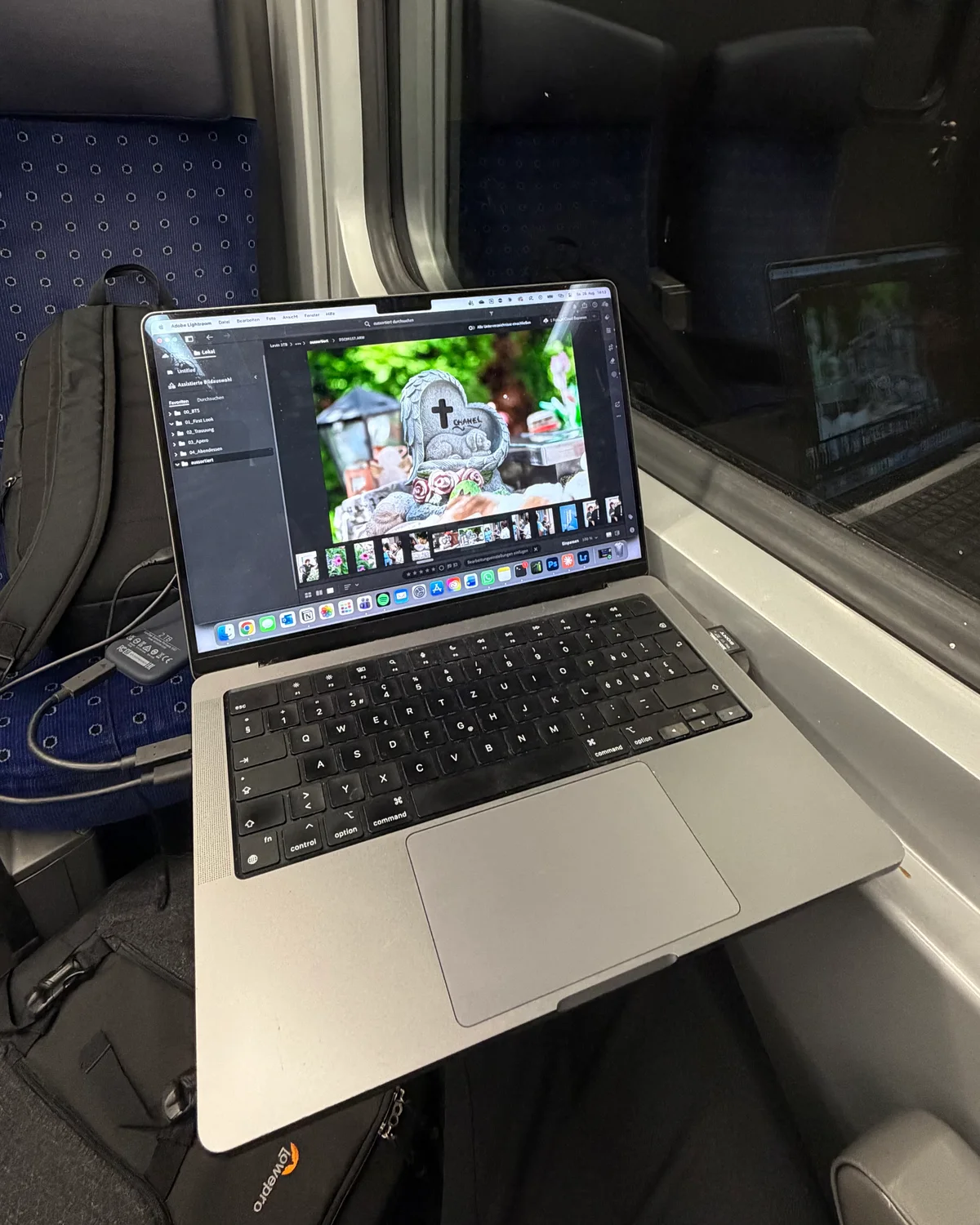 Laptop mit der Bildbearbeitung auf dem Klapptisch im Zug