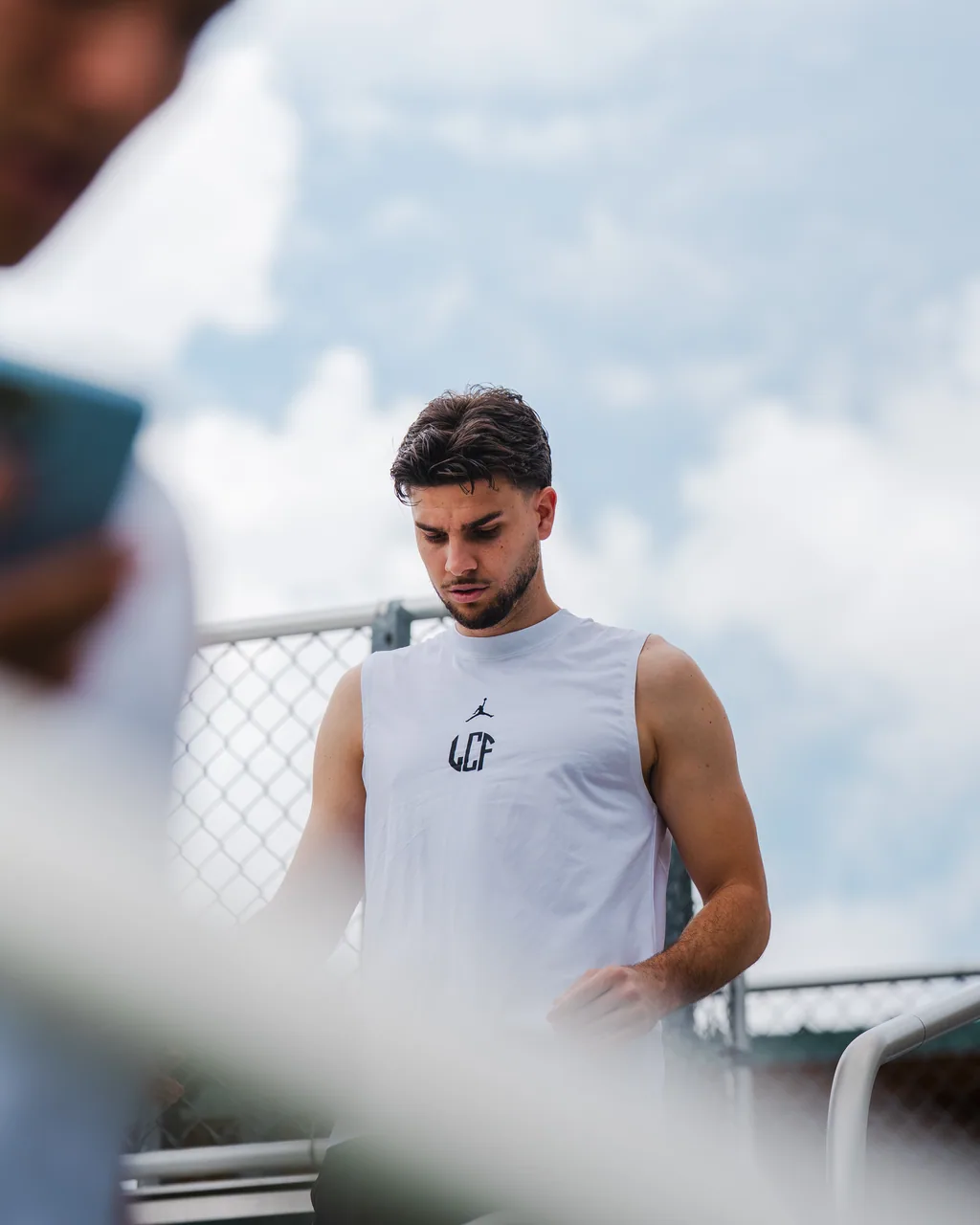 Spieler im Trainingsshirt vor dem Zaun